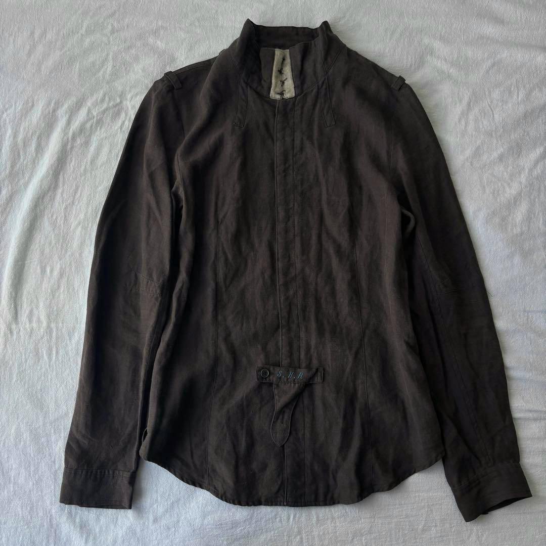 Front view of a dark linen long-sleeve shirt laid flat on a light surface.