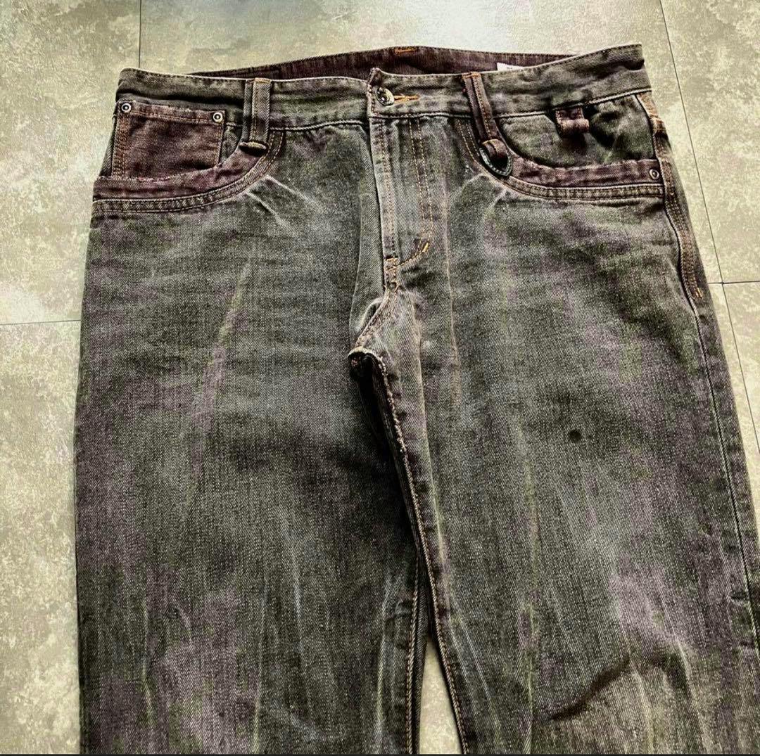 Front upper portion of black men's flare denim jeans laid flat showing waistband, pockets, fly, and top of the legs.