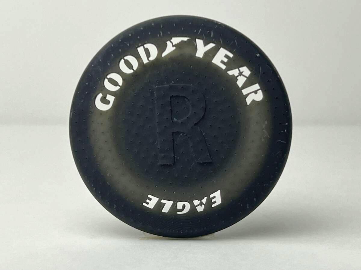 Photo of a black circular plastic 1/12-scale GOOD YEAR logo template showing the text "GOOD YEAR" and "EAGLE".