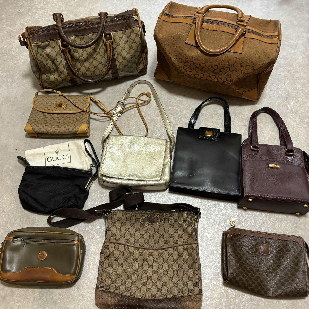 Multiple handbags and pouches, including GG-patterned Gucci pieces, arranged on a floor for a lot/set view.