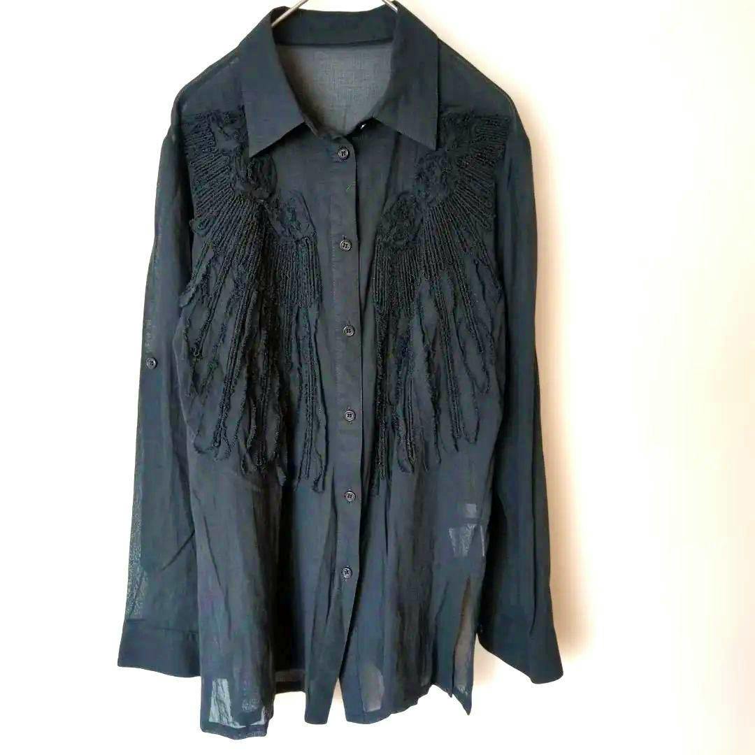 Black long-sleeve sheer button-up blouse with fringe lace detail hanging on a hanger.