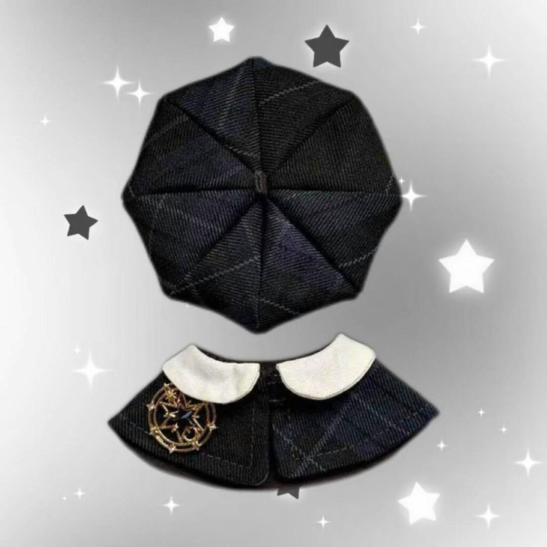 Flat-lay photo of a small dark check-pattern beret and matching cape with a white collar and decorative brooch for a 10cm doll.