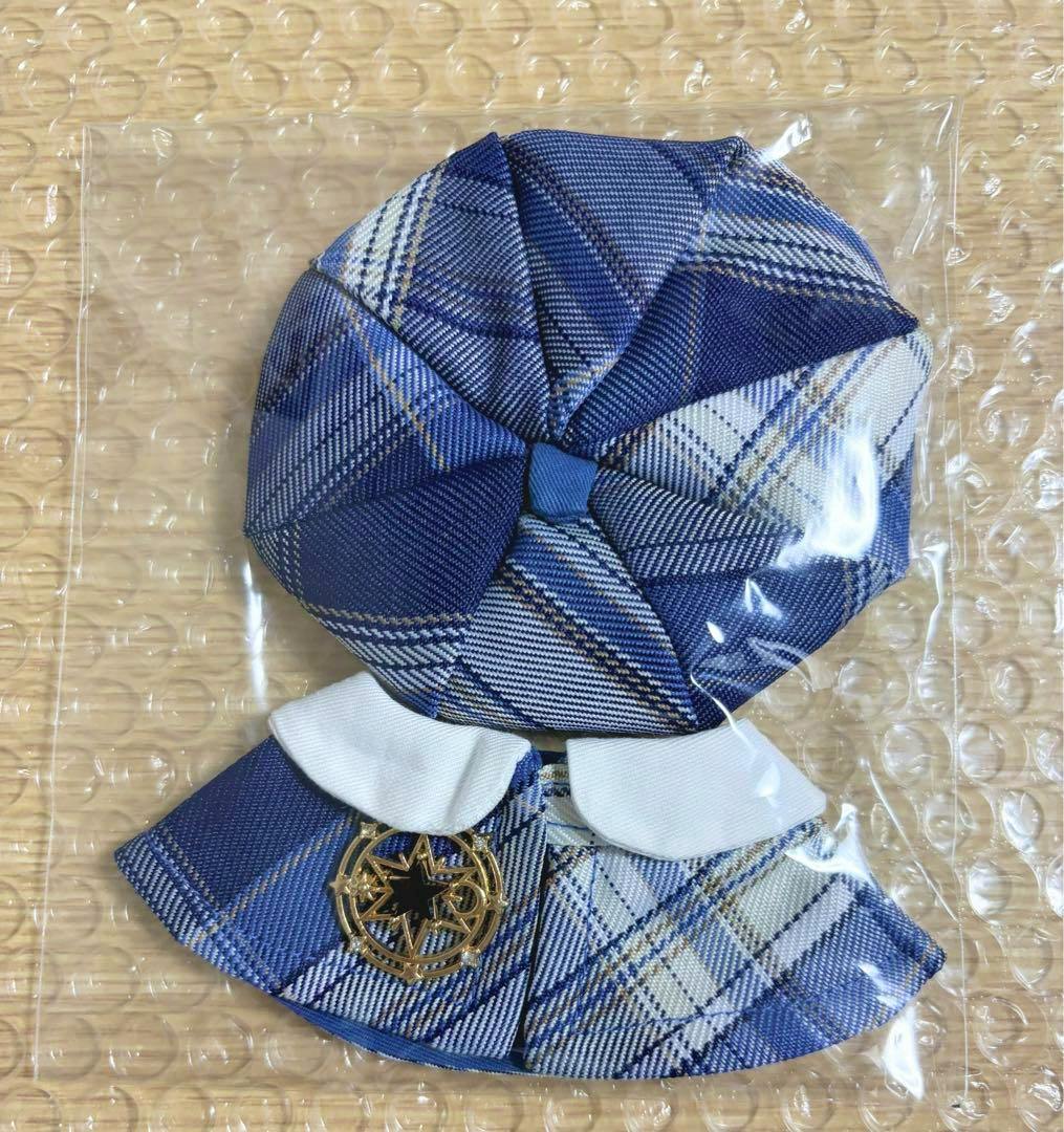 Blue two-piece doll outfit (hat and skirt) for a 10cm plush, shown in clear plastic packaging on a bubble-wrap background.
