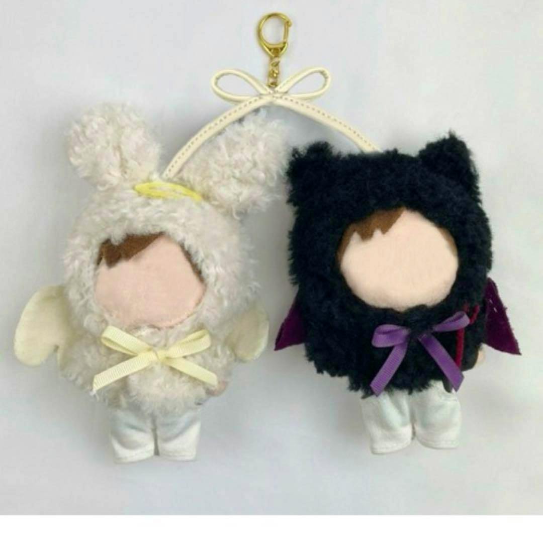 Two small plush keychain dolls wearing an angel outfit and a devil outfit, shown connected by a bow-shaped strap.