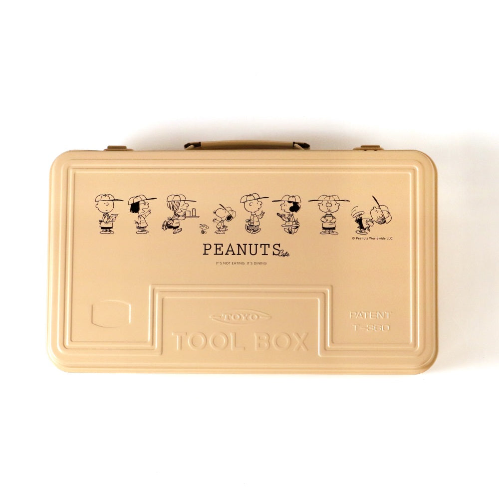 Top-down view of a beige tin tool box with Peanuts character illustrations printed on the lid.