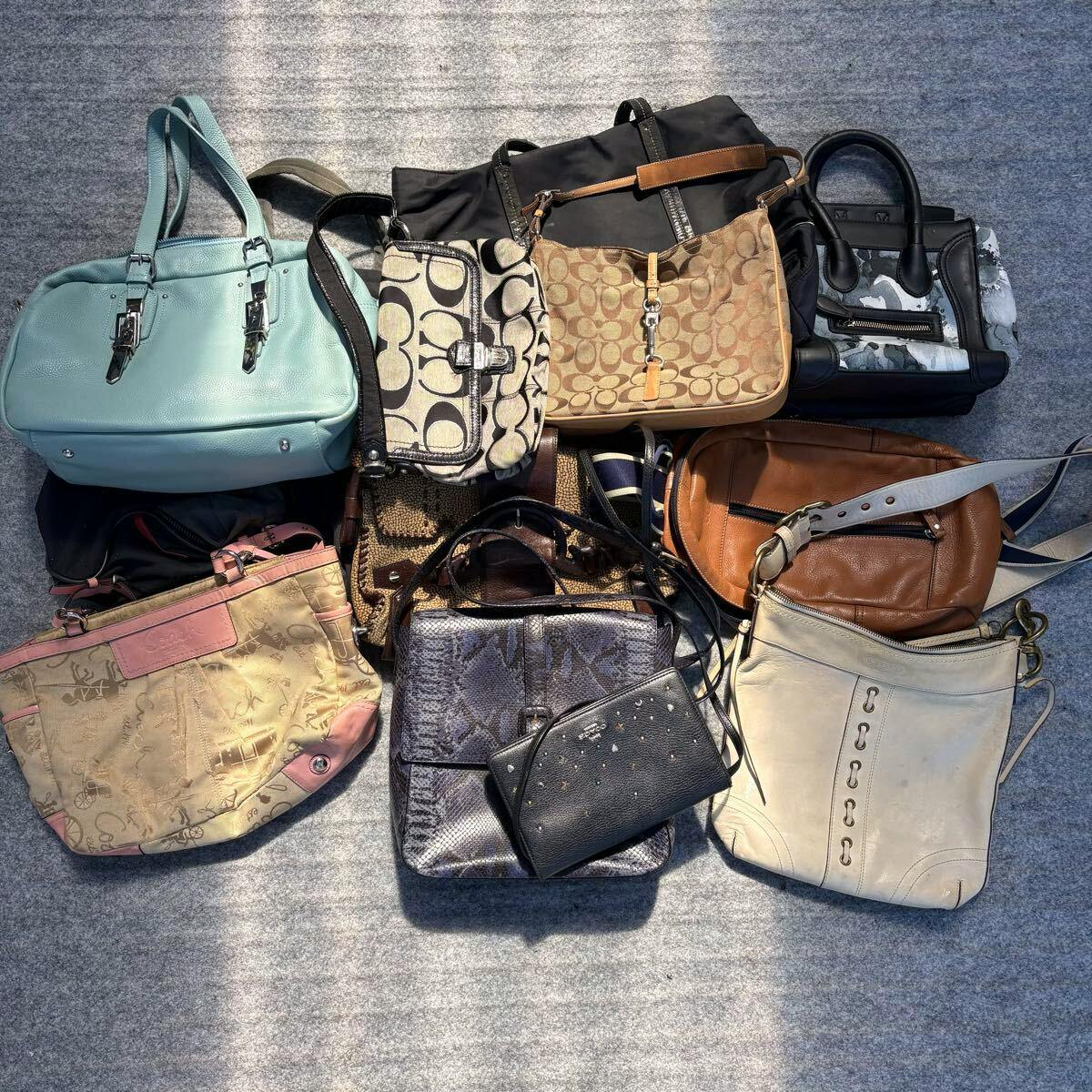 Overhead photo of multiple assorted handbags and shoulder bags laid together on a gray surface.