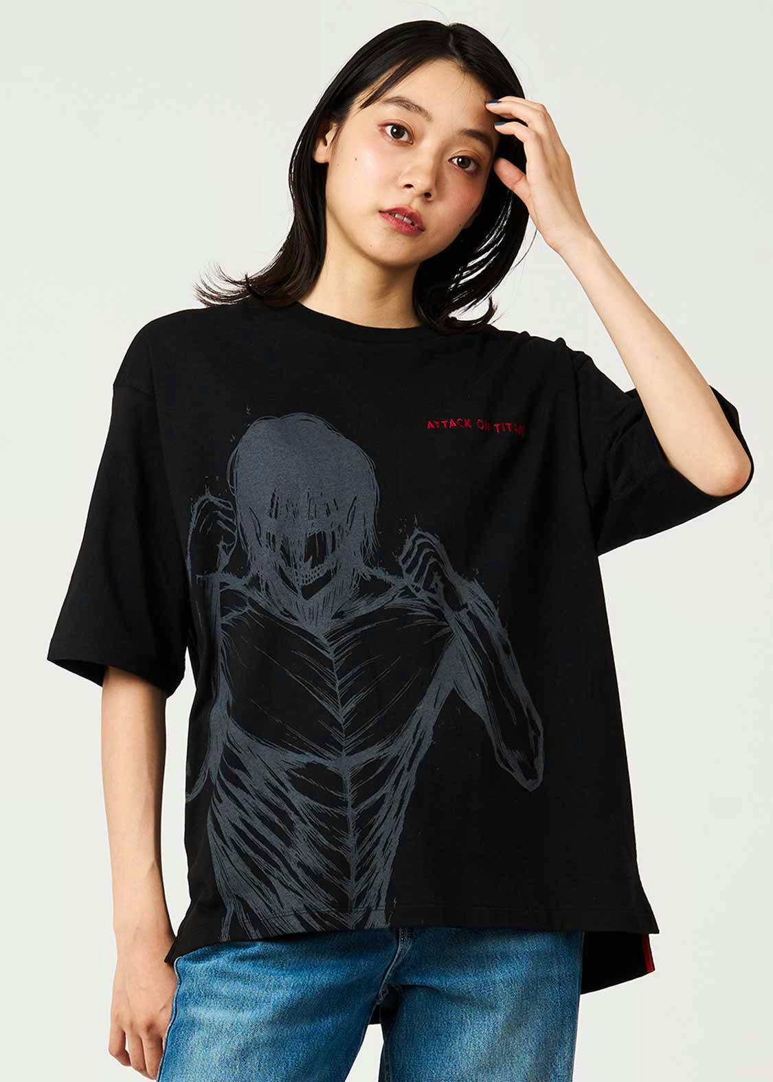 Model wearing the black big-silhouette men's cotton T-shirt showing the front with a large gray ribcage-like graphic and small red "ATTACK ON TITAN" text.