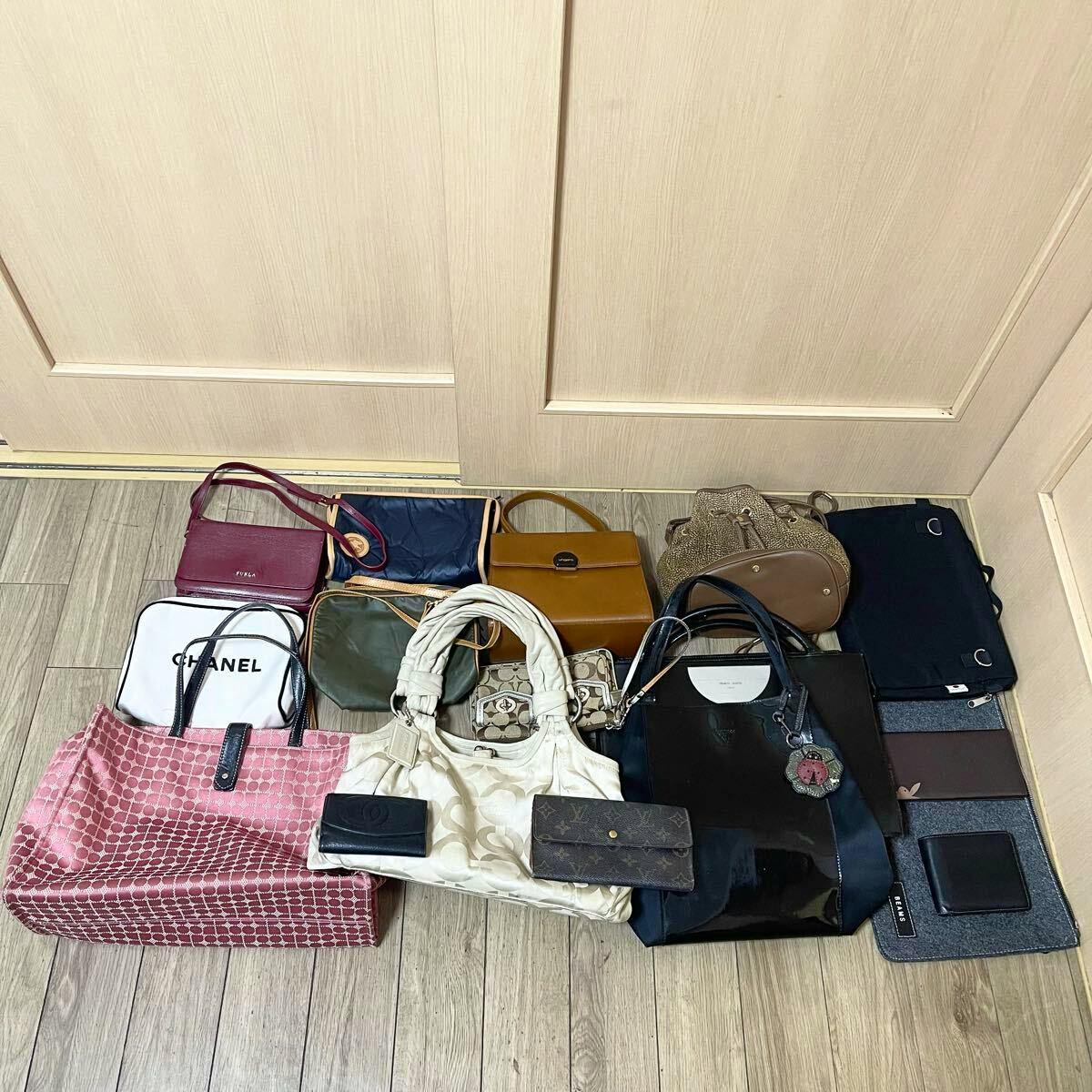 Various bags, wallets, and small accessories laid out on a wooden floor showing the set of items.