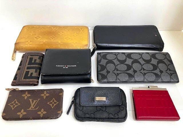 A group of assorted wallets and coin cases arranged on a white background.