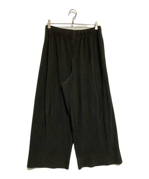 A pair of women's pleated straight wide pants (polyester) hanging on a hanger against a white background.