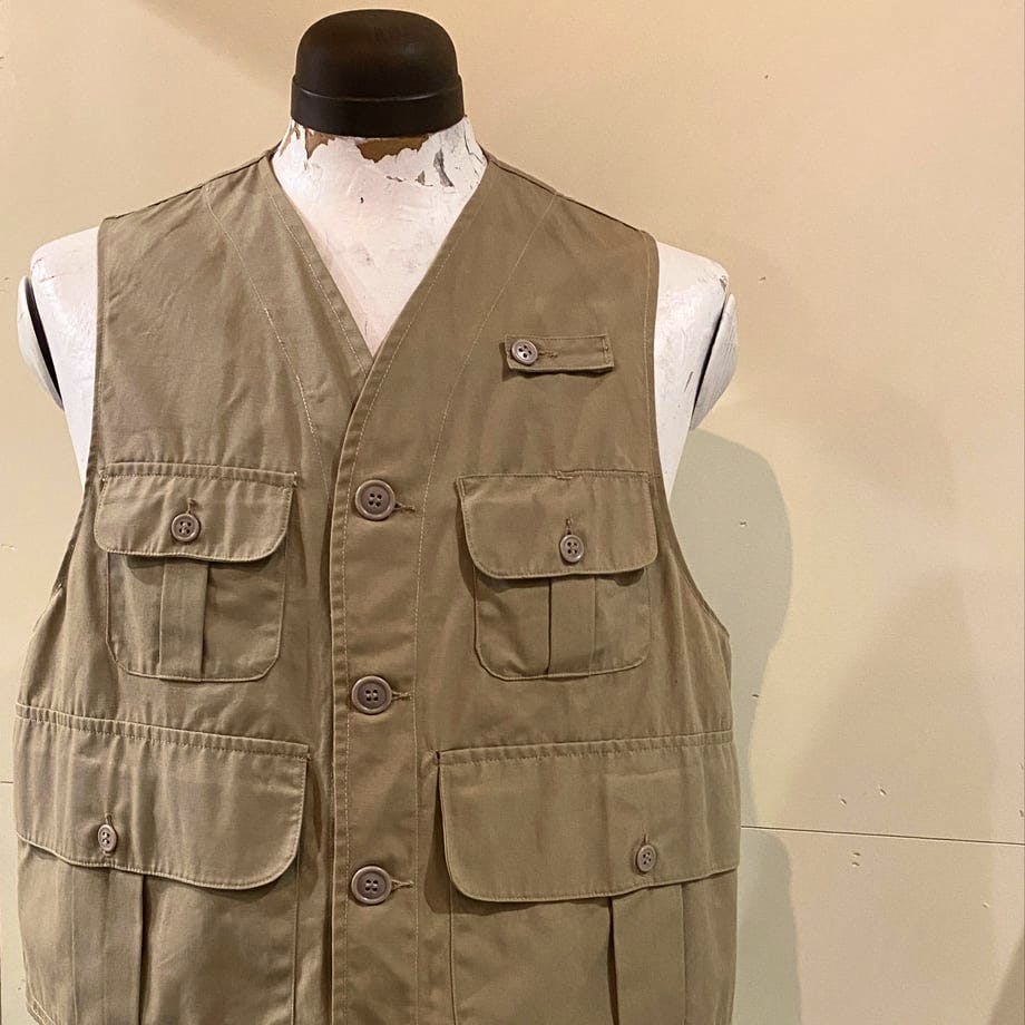 Front view of the 1940–50's Abercombie & Fitch fishing vest in khaki displayed on a mannequin, showing a button-front and multiple flap pockets.