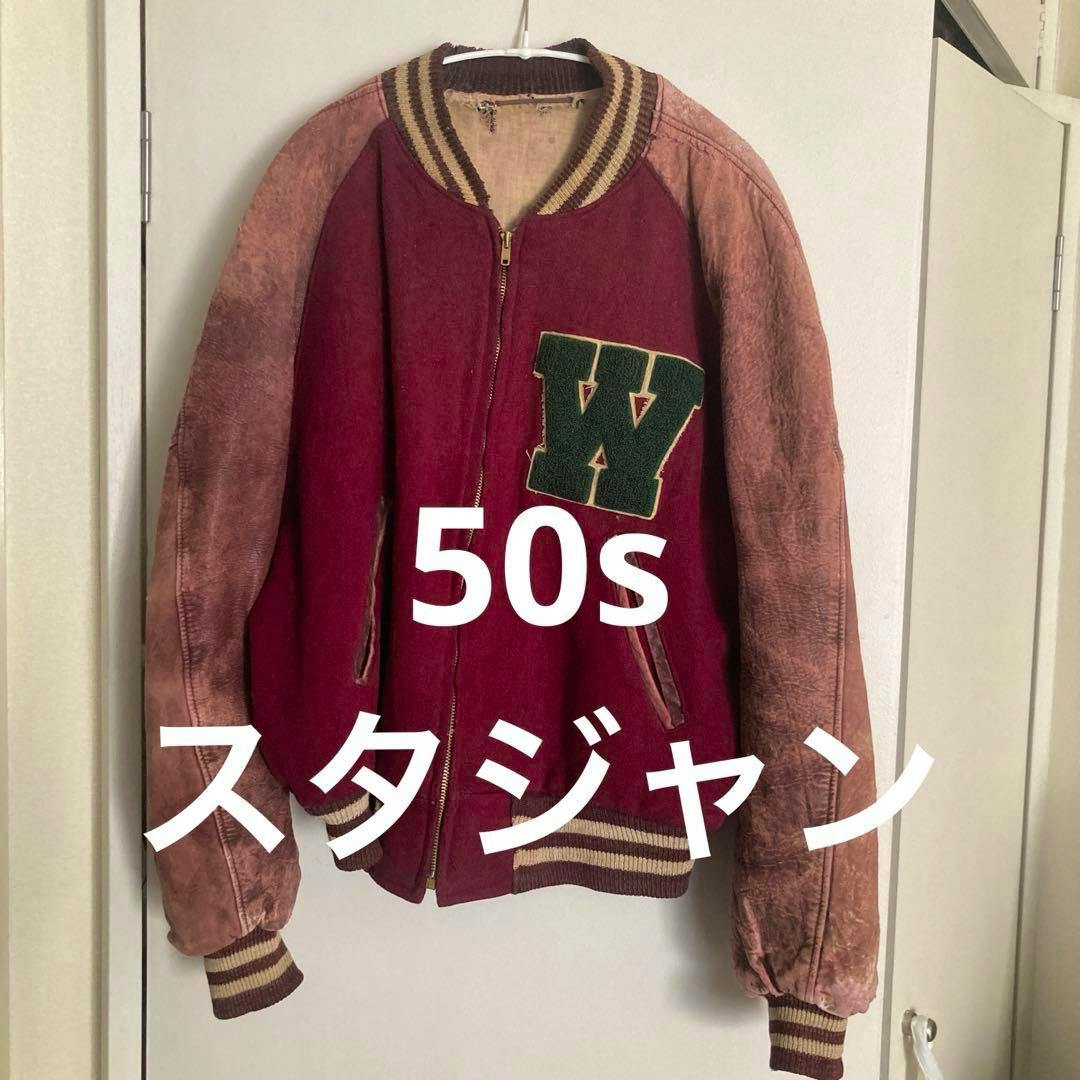 Front view of a vintage 1950s men's jacket (cotton) hanging on a hanger, maroon body with faded tan sleeves and a green letter patch, with white text overlay on the image.