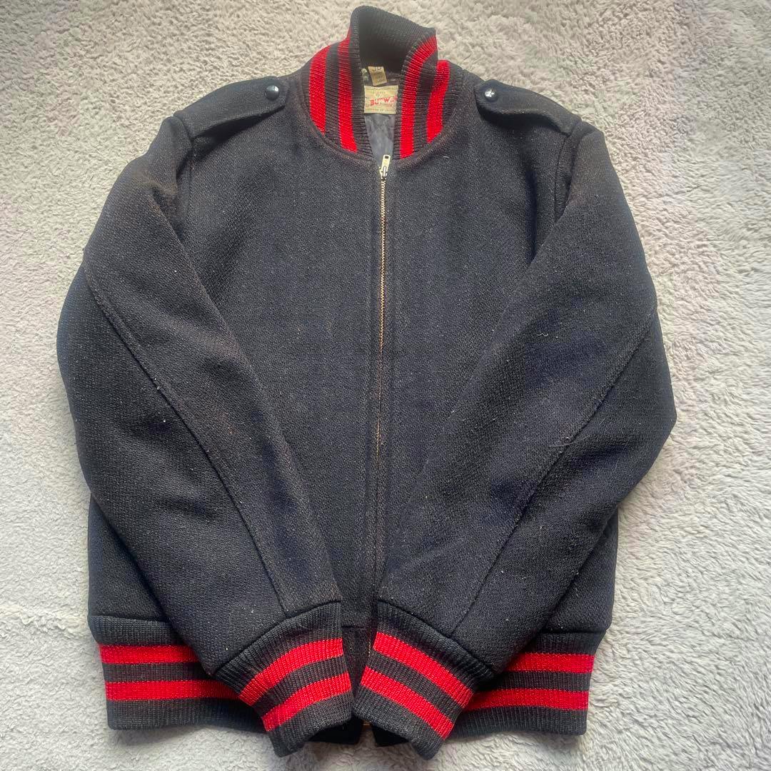 Laid-flat vintage men's cotton jacket with black body and red-striped ribbed collar and cuffs.