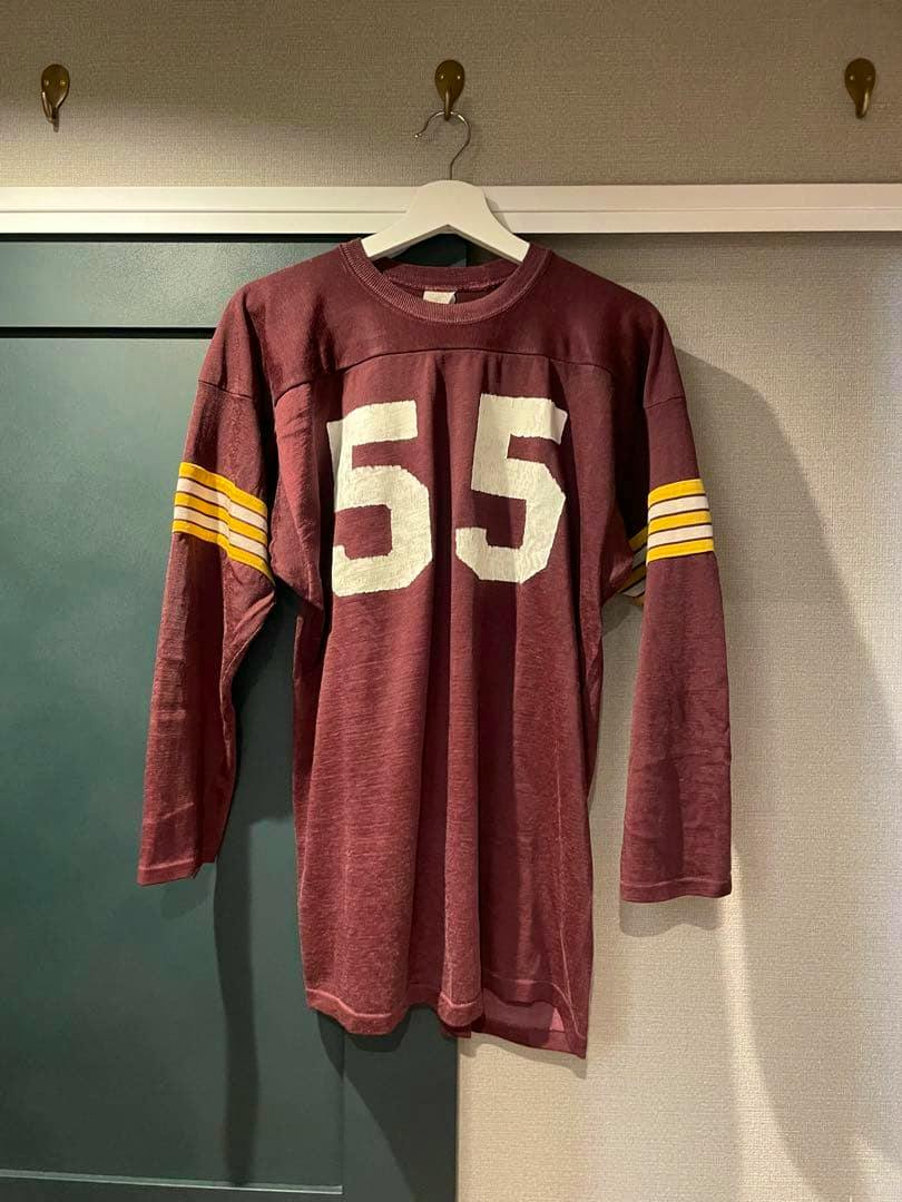 Maroon football jersey (size L) with a white "55" on the front and yellow-striped sleeves hanging on a hanger.