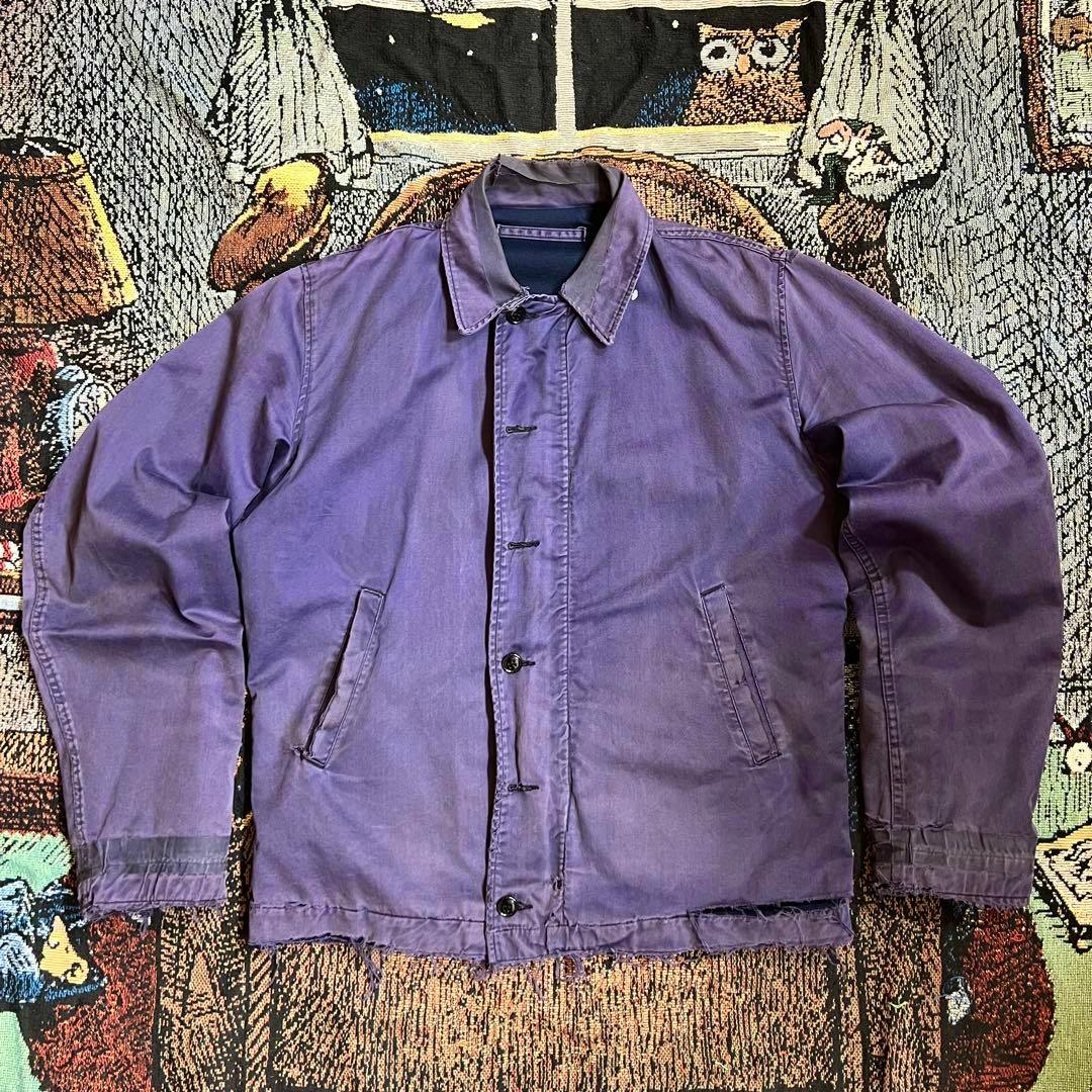 Flat-lay front view of the 60s US.NAVY men's cotton utility jacket in navy showing button closure, collar, and front pockets.