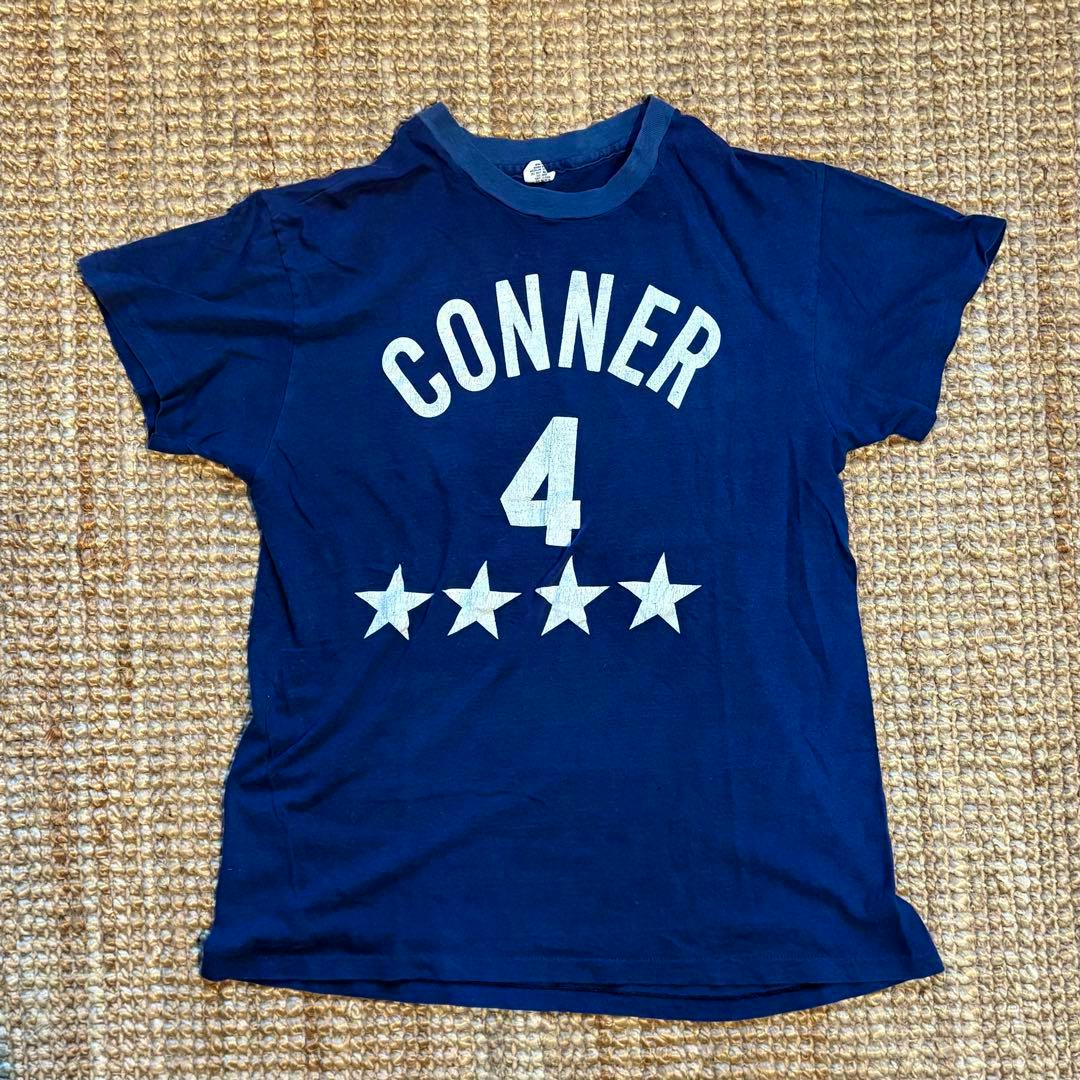 Navy vintage men's cotton T-shirt laid flat showing the front with the word "CONNER", number 4, and four stars.