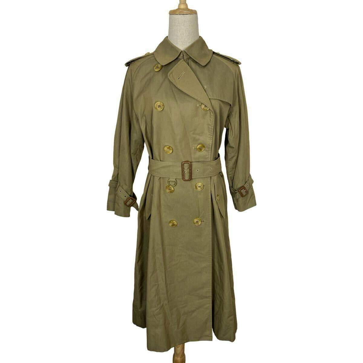 Beige vintage Burberrys women's trench coat on a mannequin, front view with belt and double-breasted buttons.