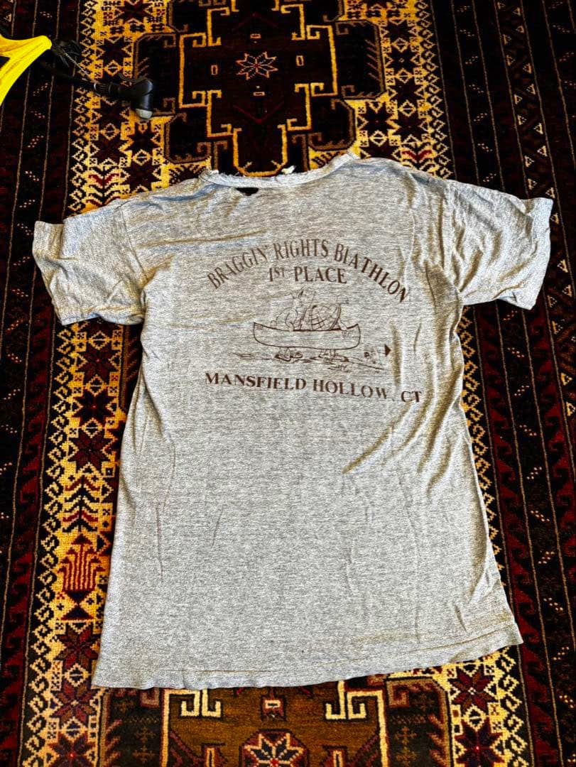 Gray heather T-shirt laid flat showing the printed back design.