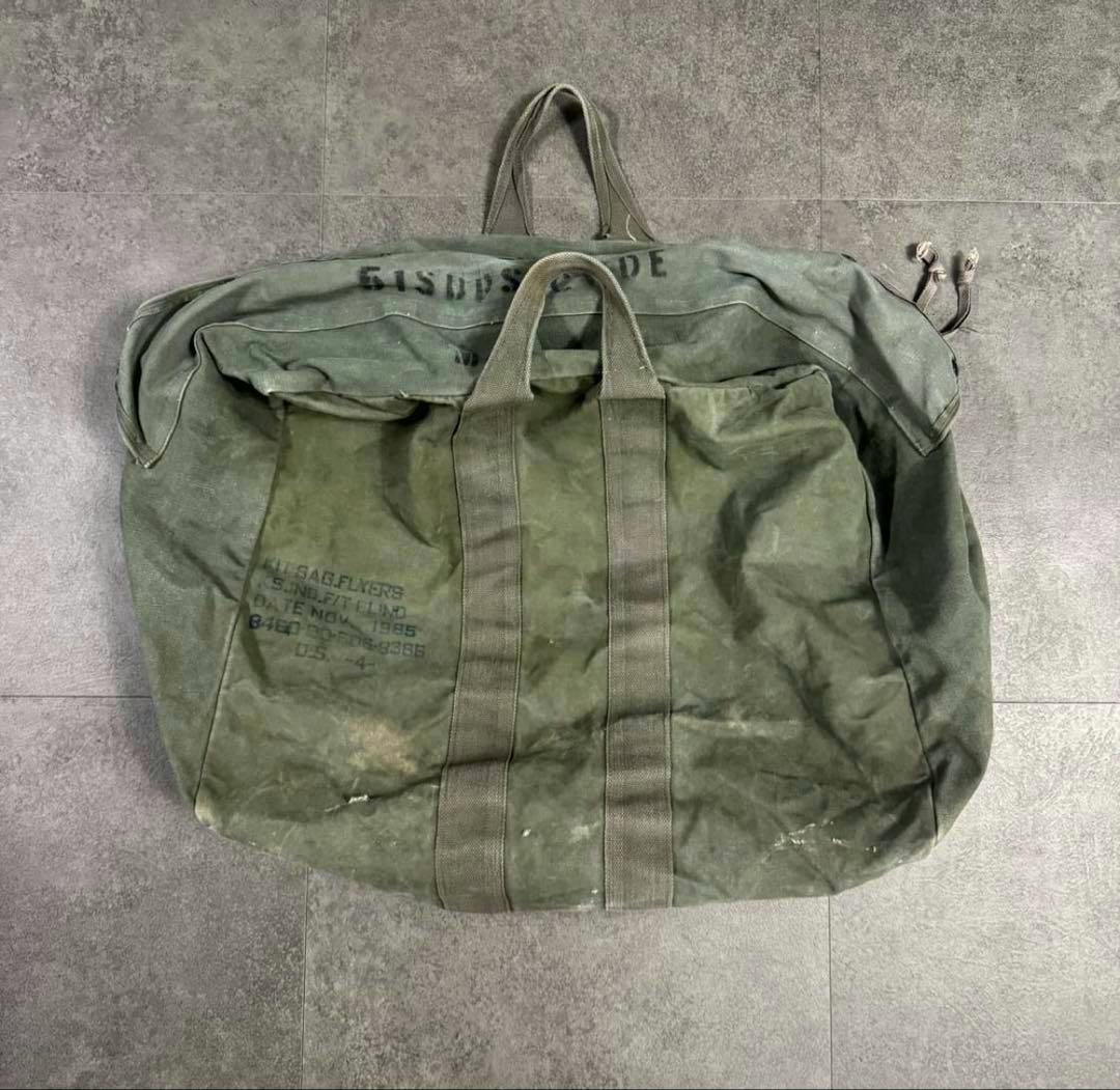 80s USAF cotton canvas flyers kit bag laid flat showing exterior handles, webbing straps, and stenciled markings.