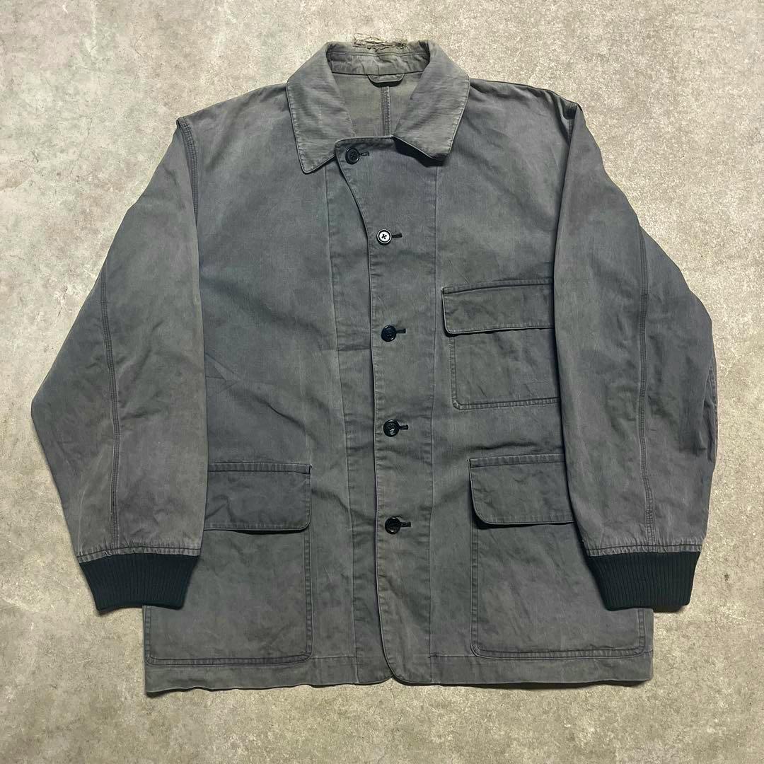 Front view of the men's cotton coverall jacket laid flat, showing the collar, button-front closure, and flap pockets.