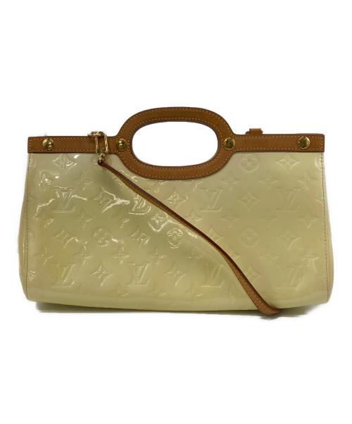 Front view of the cow leather 2WAY bag with embossed monogram pattern, brown leather handles, and a shoulder strap attached.