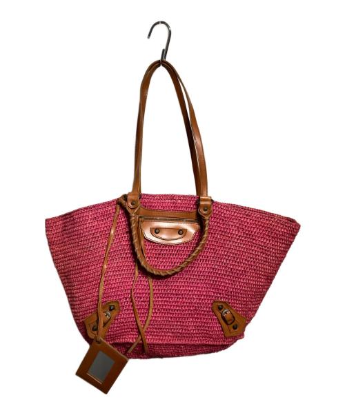 Pink woven 2WAY tote bag with brown cow leather handles and accents hanging on a hook.