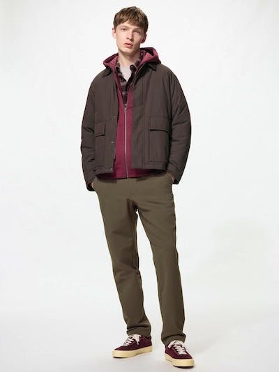 Male model wearing the nylon pants in a full-length shot, styled with a jacket and sneakers.