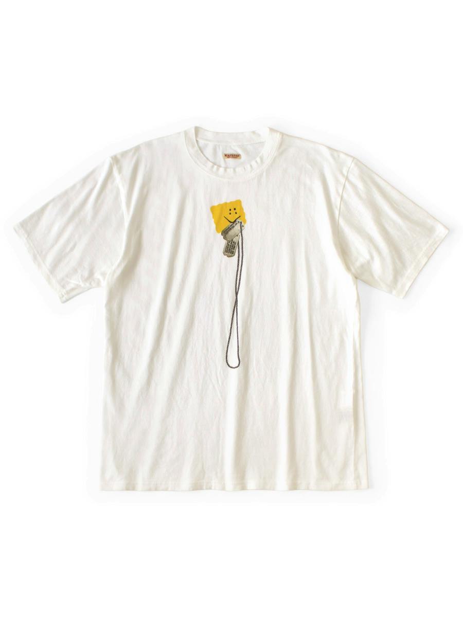 Front of a white cotton crew T-shirt laid flat showing a small yellow smiling square and a printed dog-tag graphic.