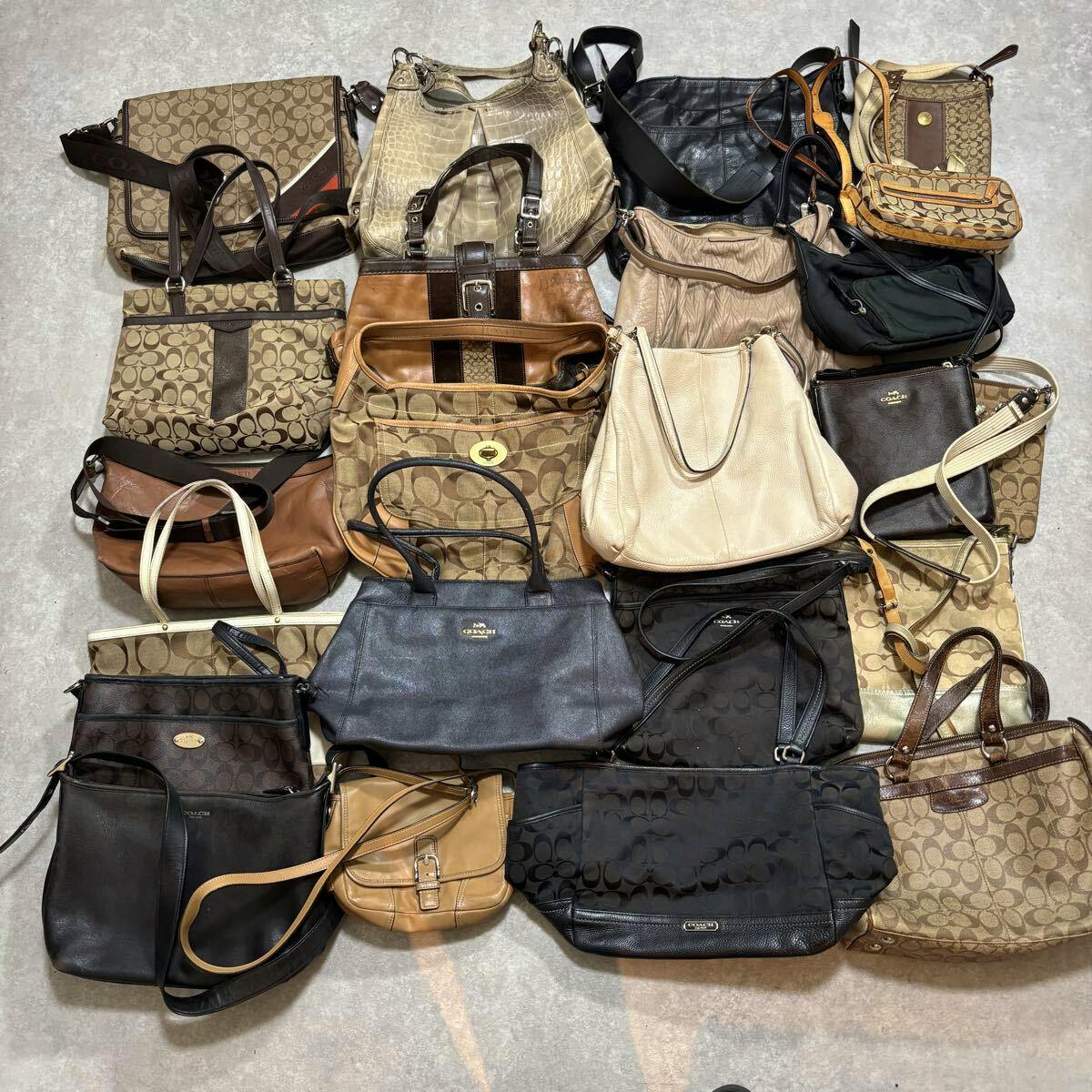 A collection of Coach handbags and totes arranged on the floor as a grouped lot.