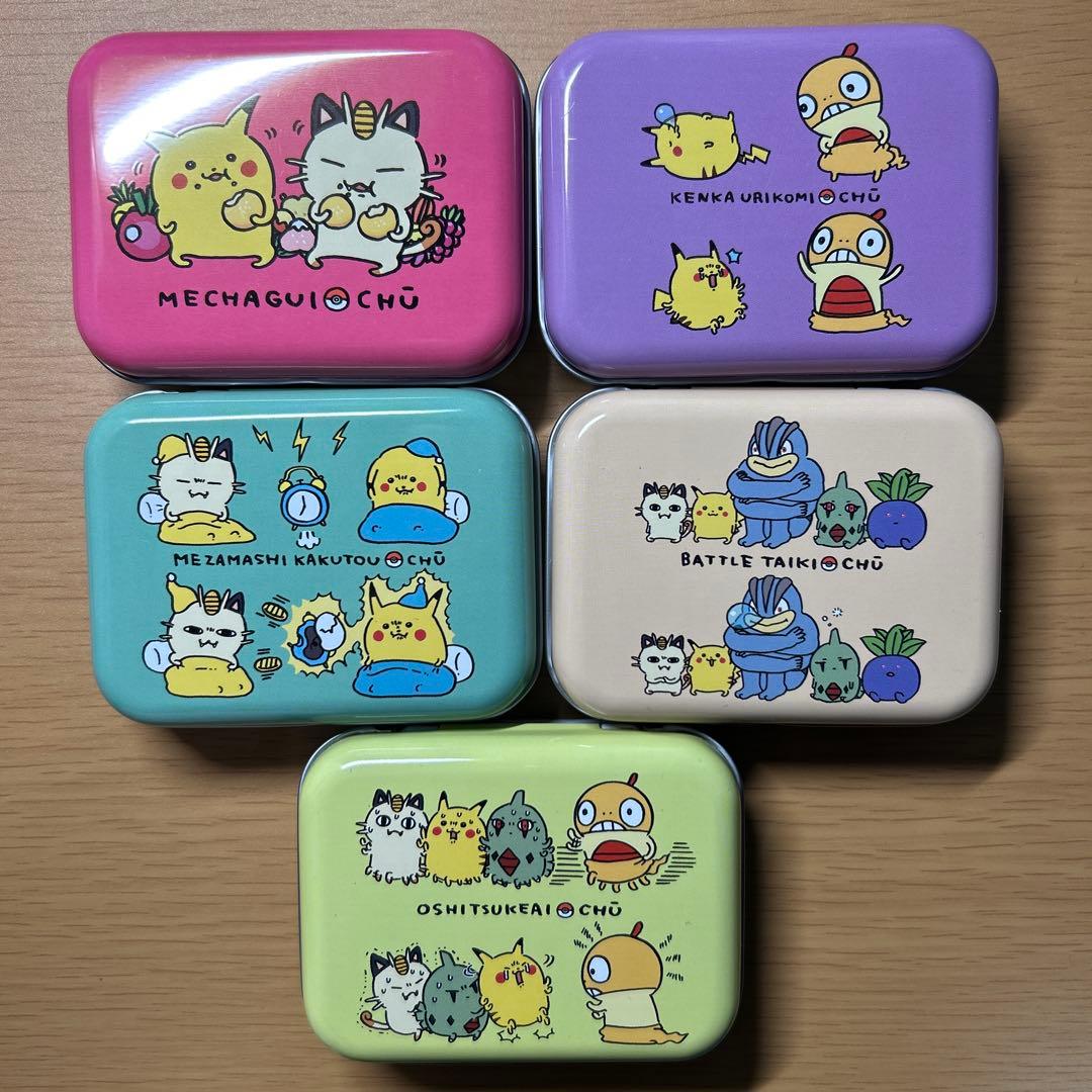 Five small rectangular can cases with Pokémon CHU character illustrations in different pastel colors arranged on a wooden surface.