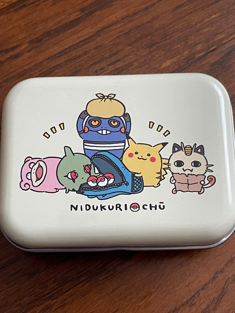 Rectangular aluminum tin can showing illustrated Pokémon characters on the lid.
