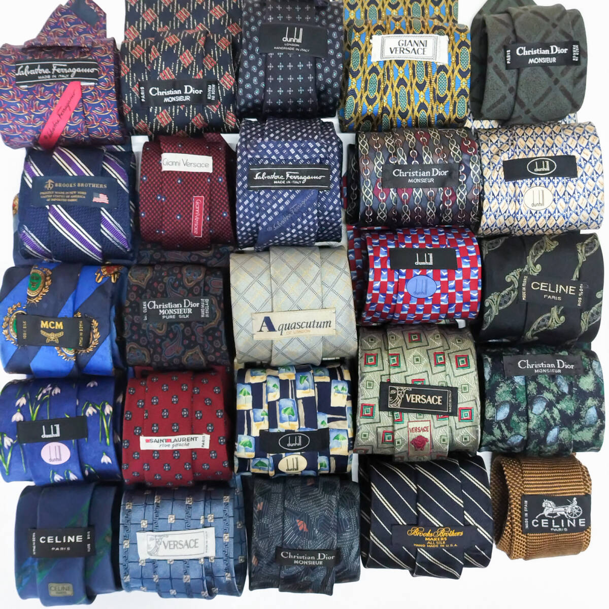 A grid of rolled silk neckties in assorted designer patterns and colors displayed together.