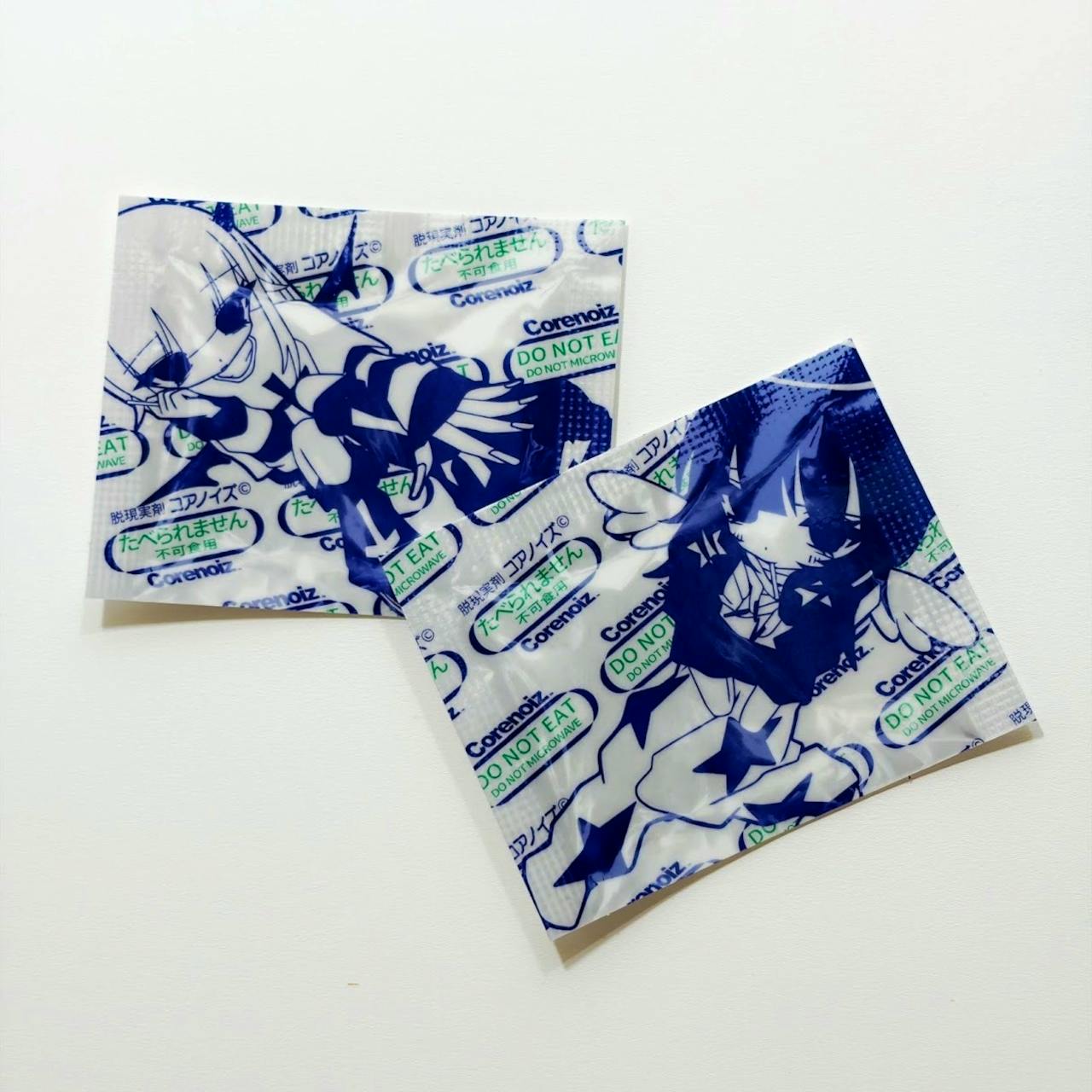 Two plastic stickers from the 2604 食べられません sticker pack showing blue anime-style illustrations and repeated "DO NOT EAT" text on a white background.