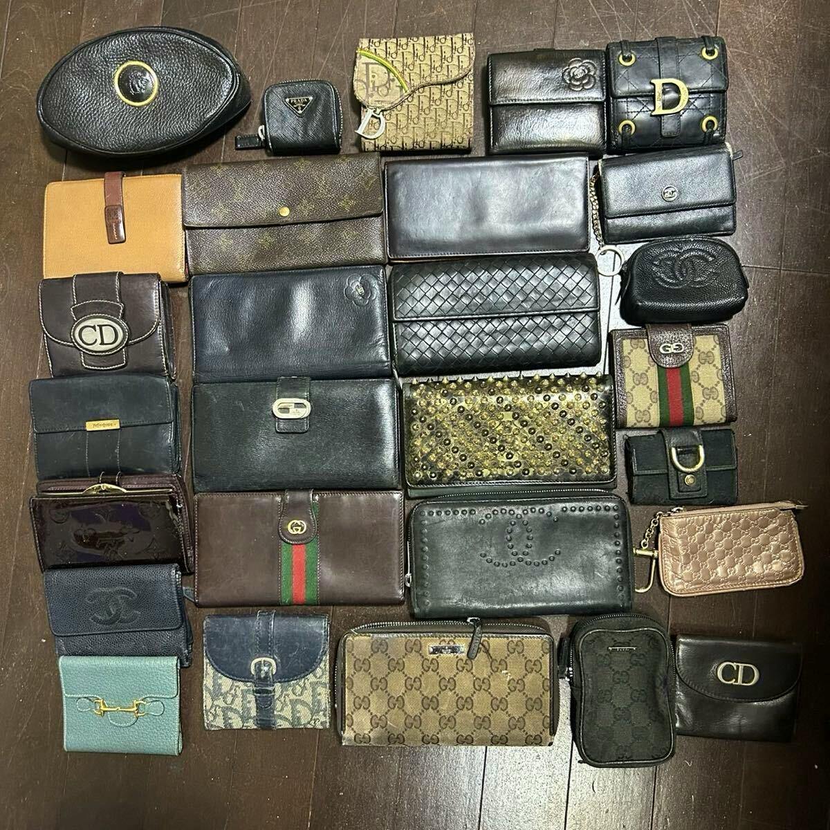 Multiple assorted branded wallets and small pouches arranged on a wooden floor, photographed from above.