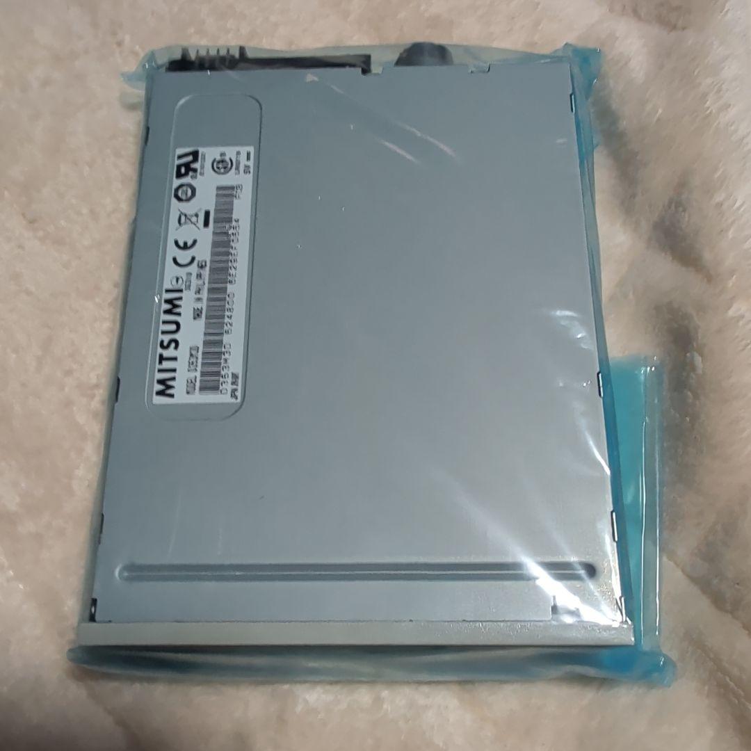 Top view of a 3.5-inch floppy disk drive wrapped in blue protective film.
