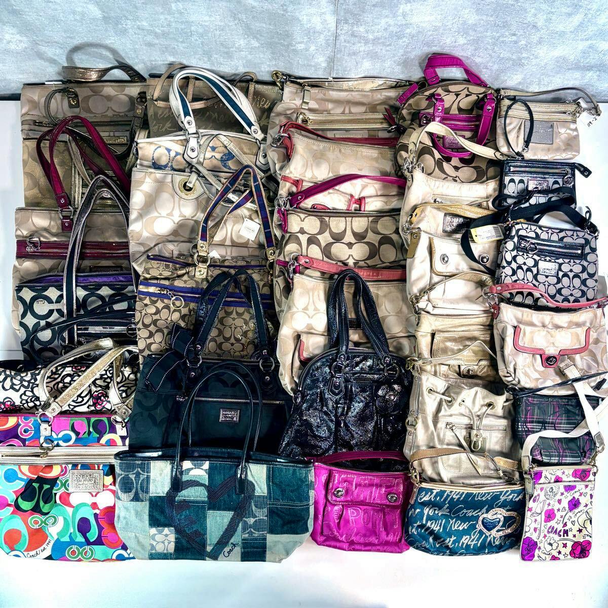 A large assortment of Coach bags and totes in various colors and patterns arranged together as a bulk set.