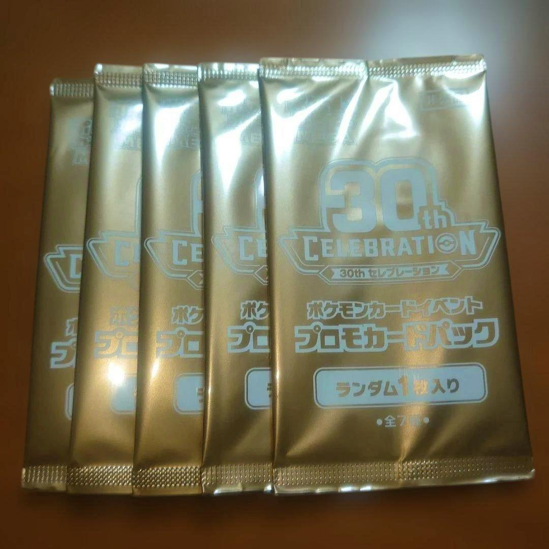 Front view of five gold 30th Celebration promo card packs for Pokémon arranged side by side.