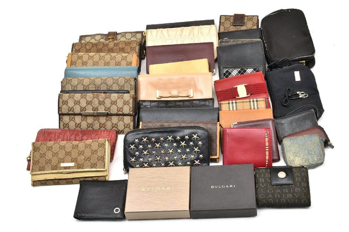 A collection of assorted wallets, key cases, and pouches laid out on a white background.