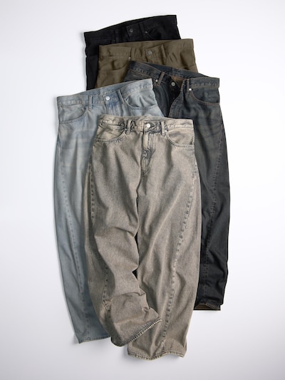 Multiple pairs of men's jeans in different washes laid flat overlapping on a white background.