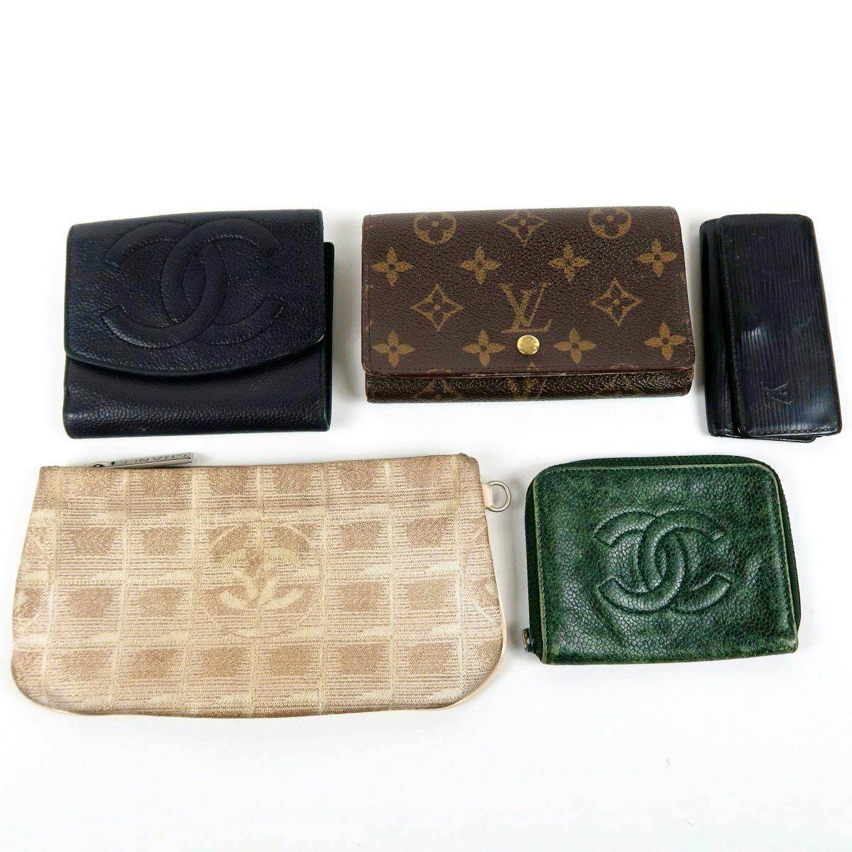 Five branded small leather goods (wallets, key cases, and pouches) including Chanel and Louis Vuitton items arranged on a white background.