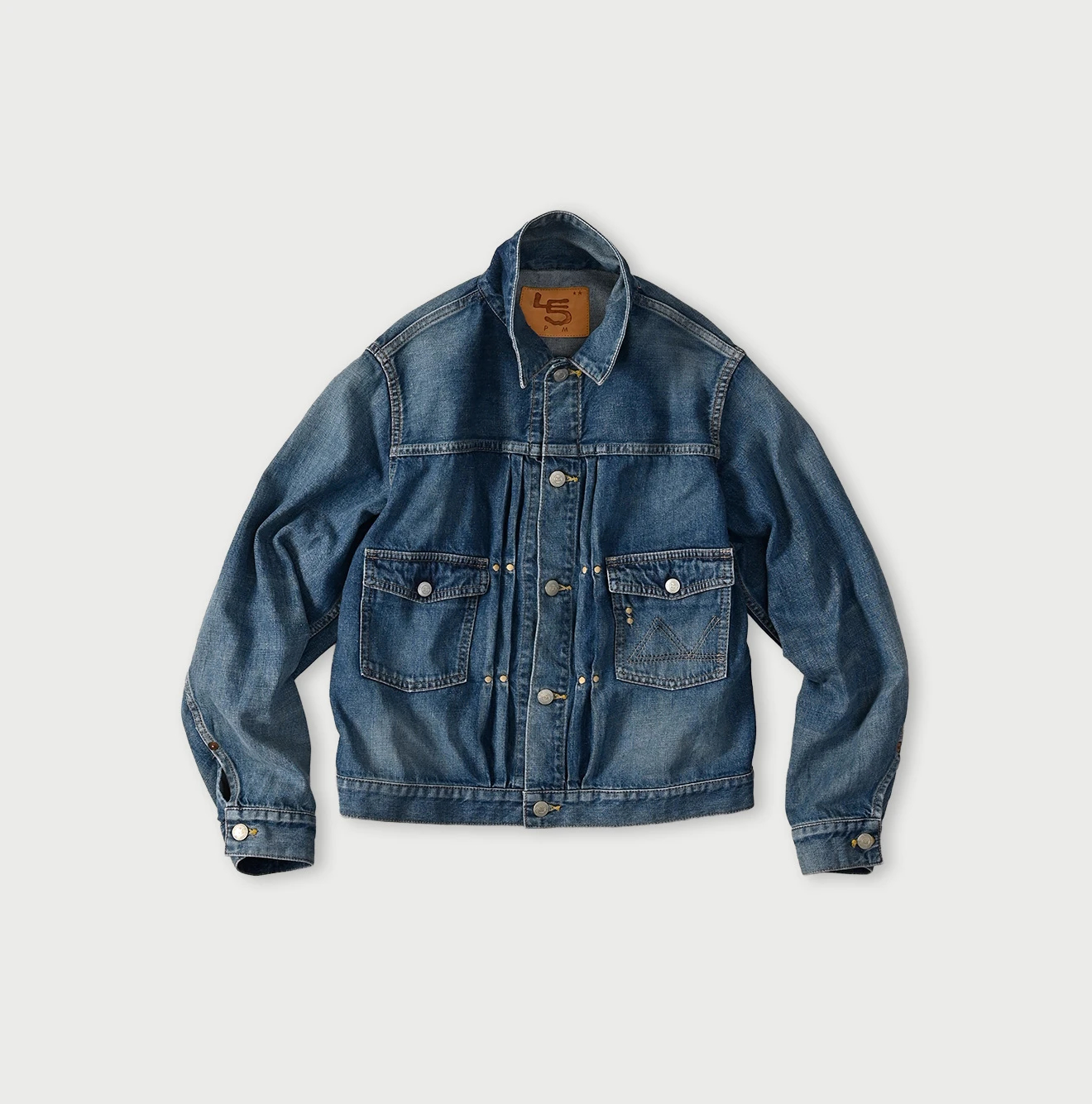 Front view of a women's blue denim jacket laid flat with button closure and two front flap pockets.