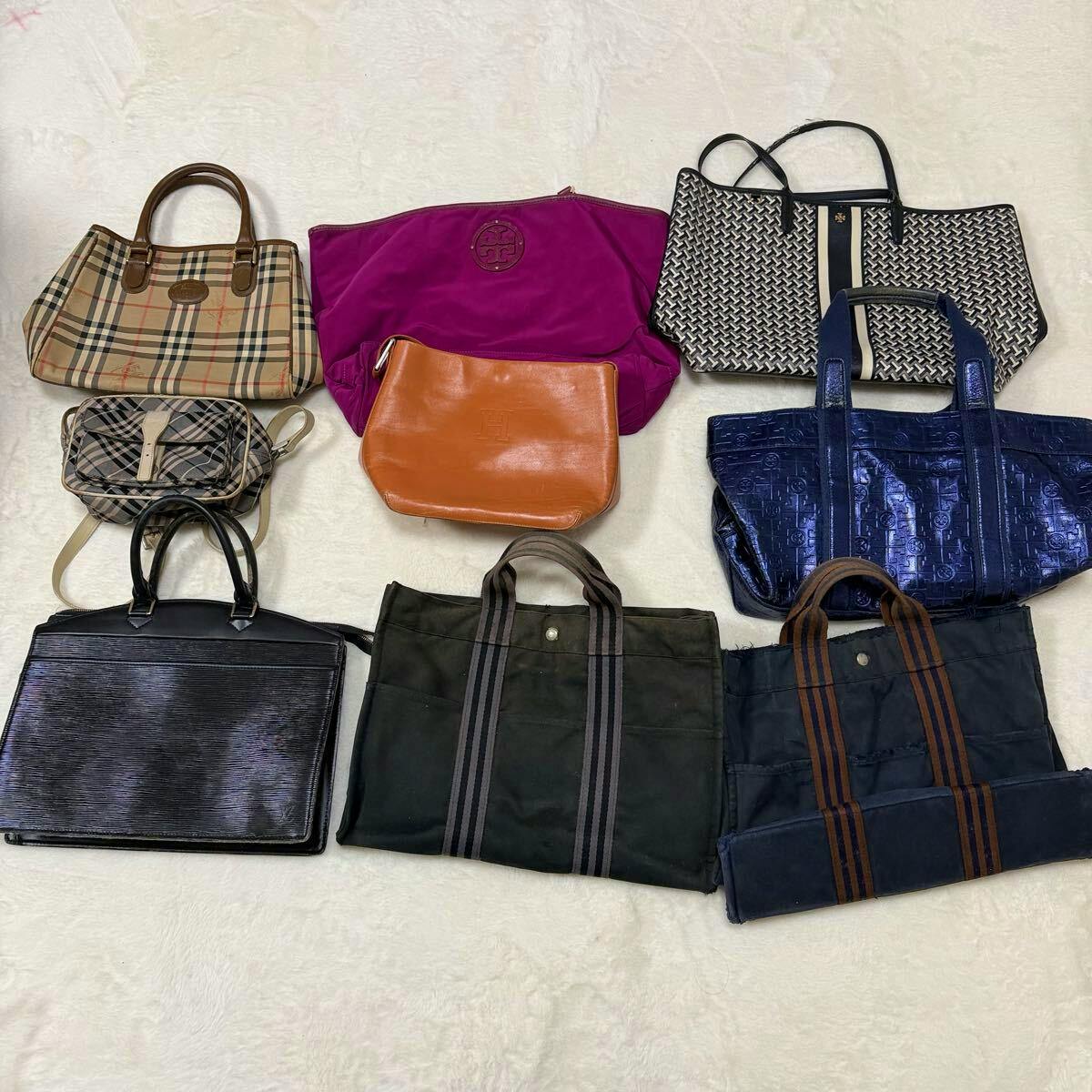 A set of assorted handbags and tote bags arranged on a light surface.