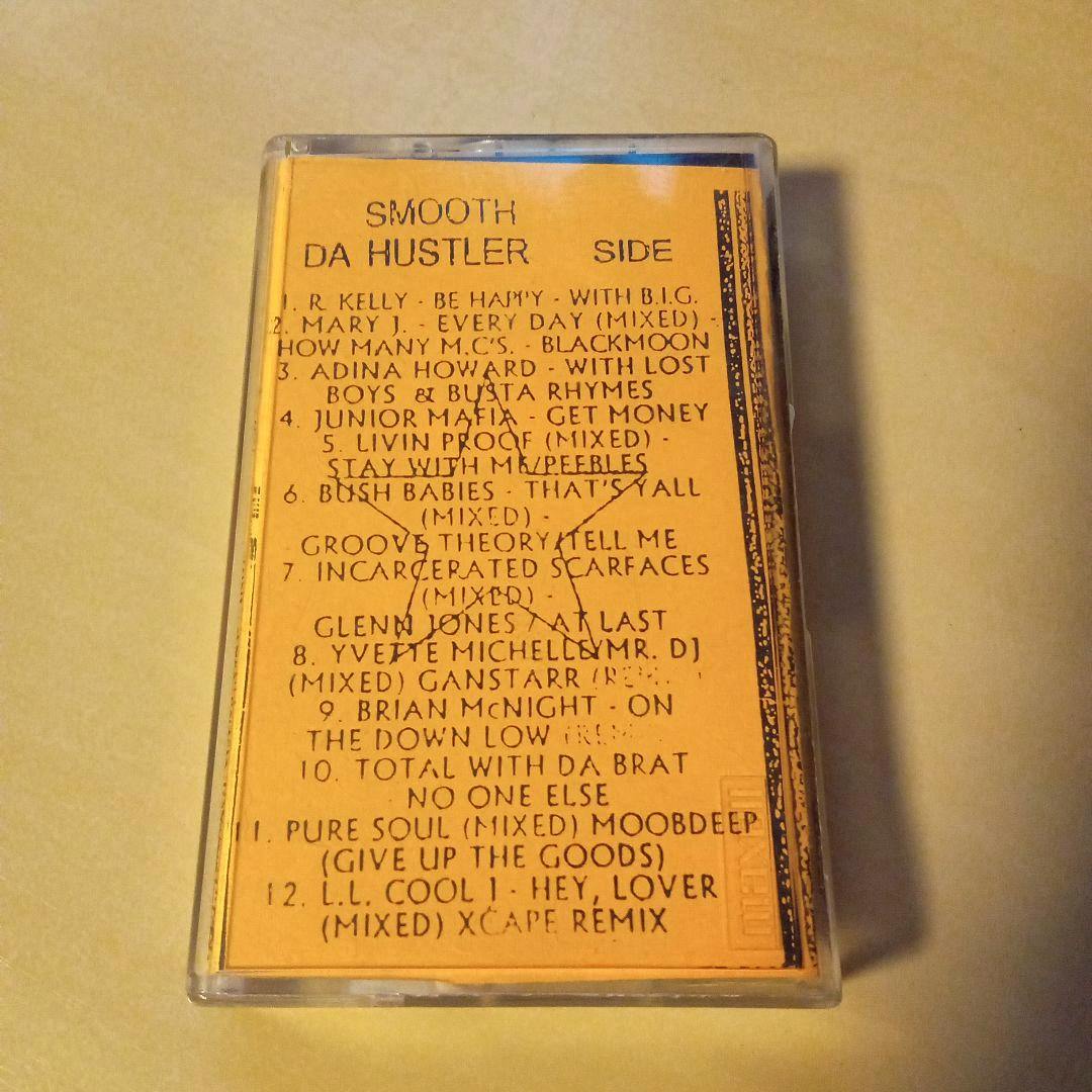 Cassette tape case with a yellow-orange tracklist insert showing 'SMOOTH DA HUSTLER SIDE'.