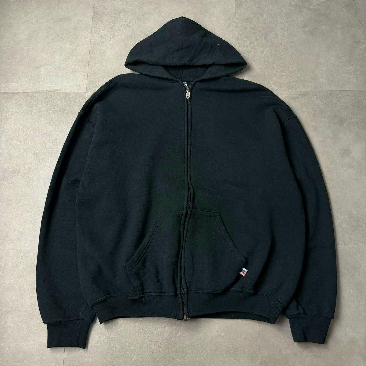 Black full-zip Russell parka laid flat showing hood, zipper, and front pockets.