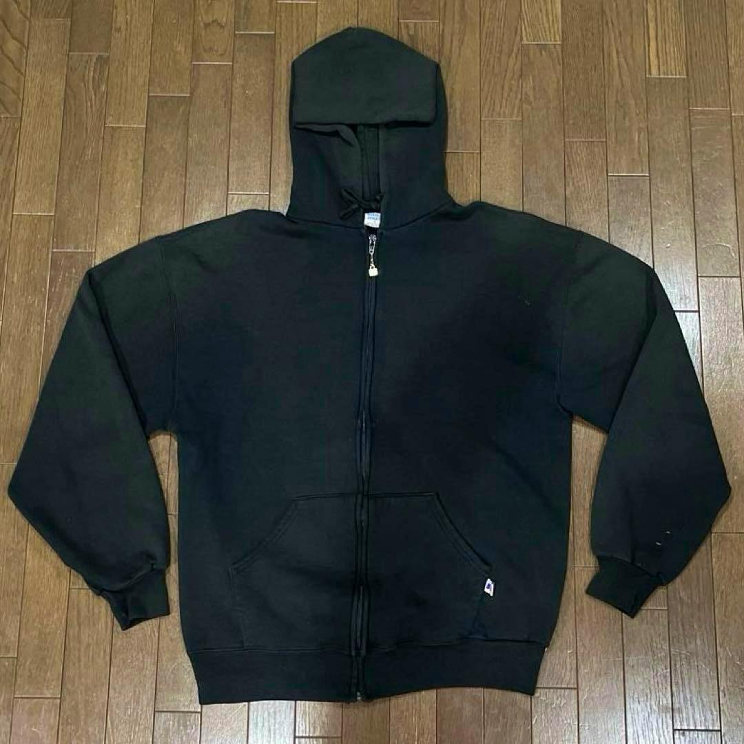 Black full-zip hooded sweatshirt laid flat showing the front, zipper, kangaroo pocket, and a small tag.