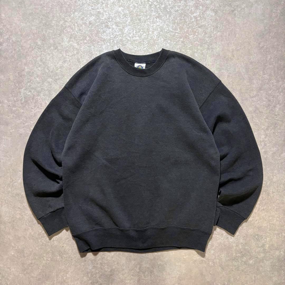 Flat-lay photo of a black blank cotton crewneck sweatshirt laid flat on a light background.
