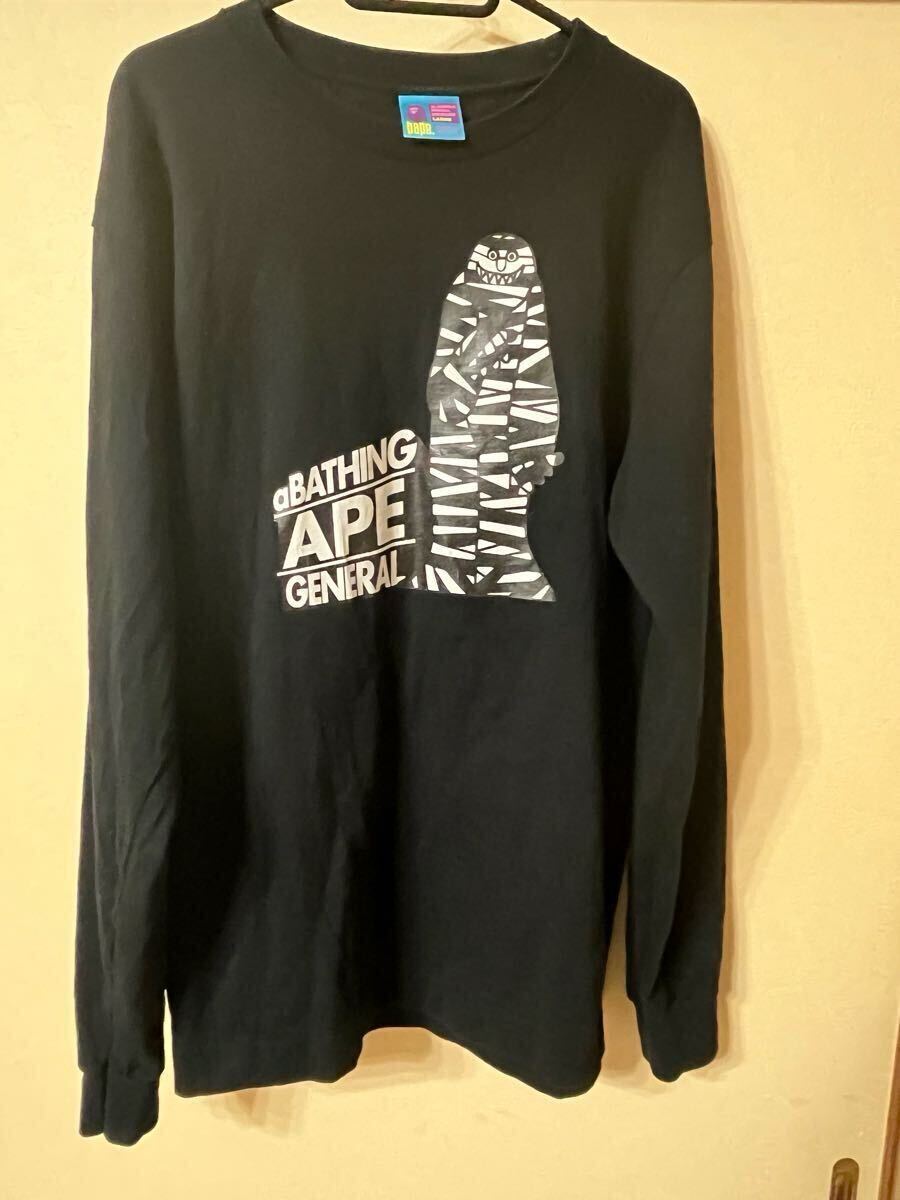 Black long-sleeve A BATHING APE T-shirt with a mummy graphic and text, hanging on a hanger.