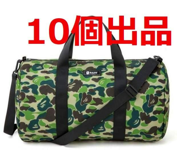 Green camo canvas A BATHING APE duffle bag with black handles and a shoulder strap, with red Japanese text overlaid.