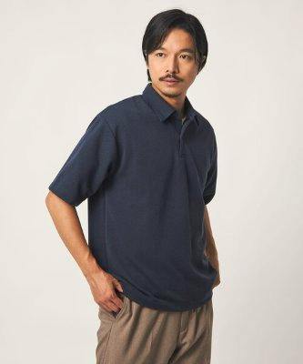 Male model wearing a navy short-sleeve polo shirt posed against a plain light background.