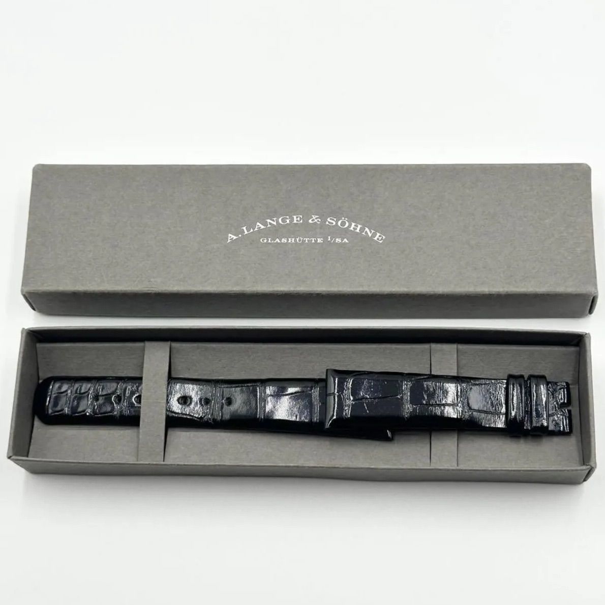 Black leather watch strap displayed inside an A. Lange & Söhne branded box.